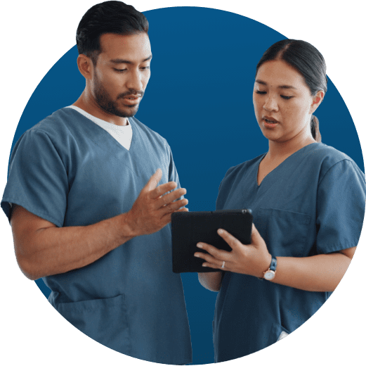 Lakeshore Bone & Joint Orthopedic Urgent Care | Two healthcare professionals in scrubs, a man and a woman, discussing medical information on a digital tablet.